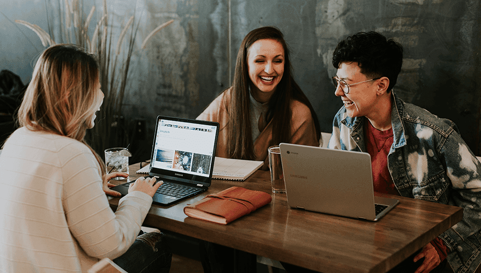 people smiling working on laptops