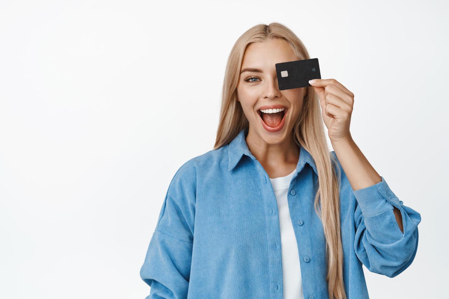 young woman holding a black credit card in her hand