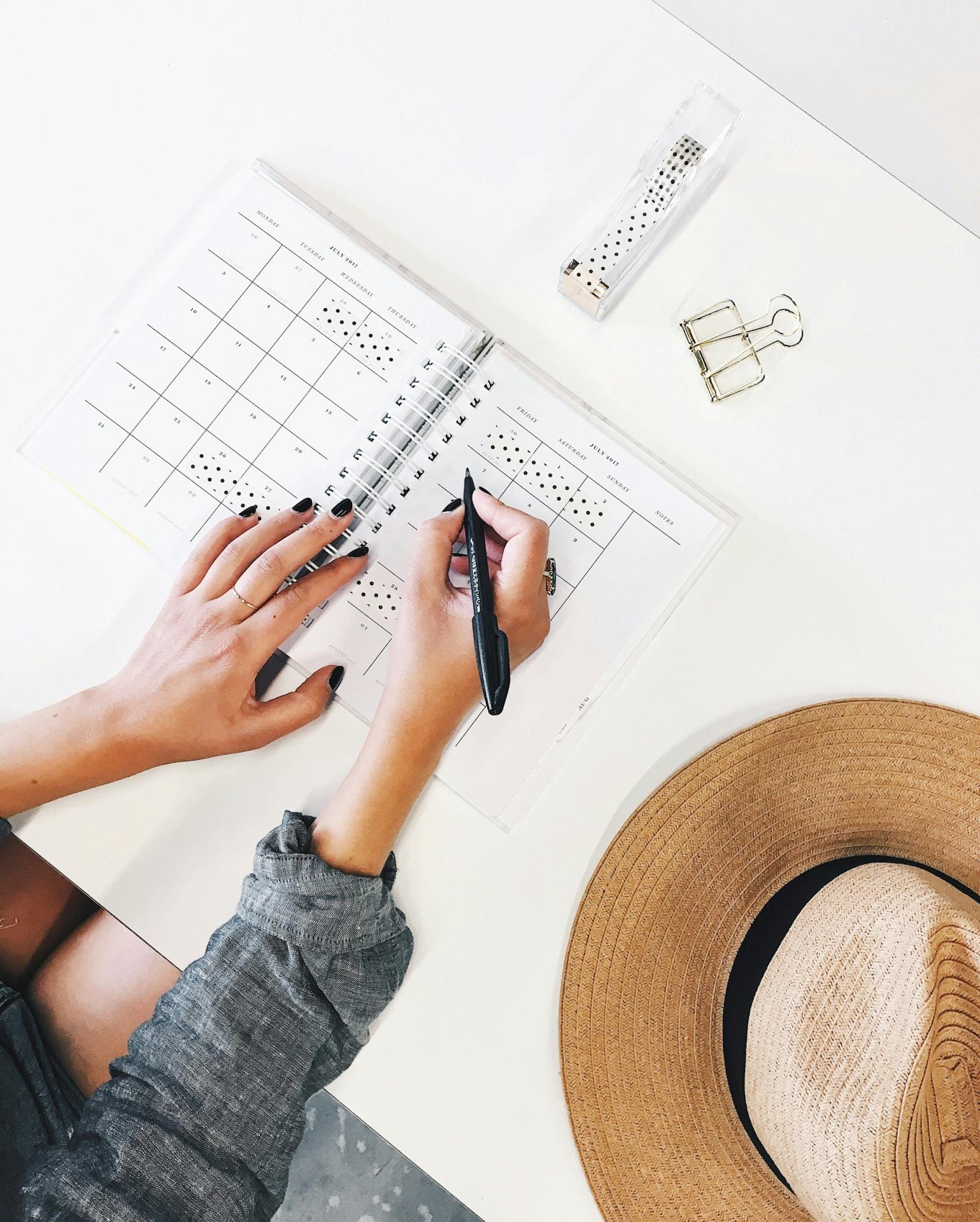 women writing something in the paper calendar