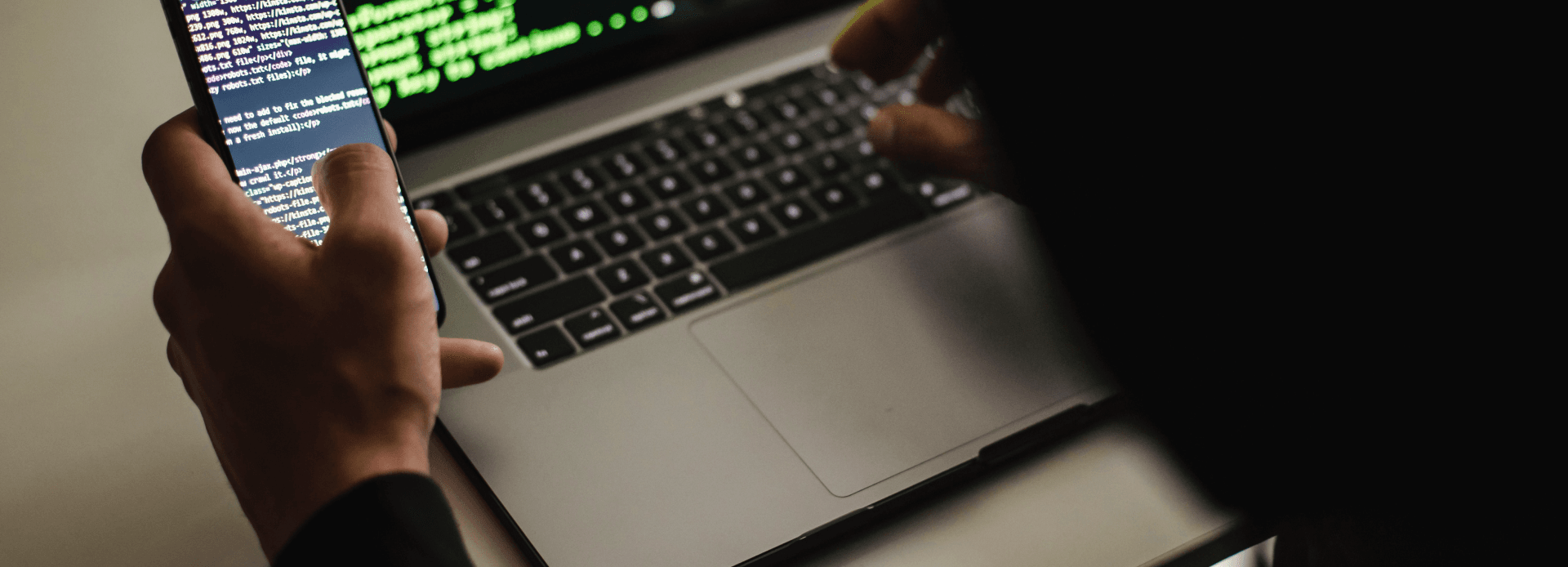 a programmer working on the computer and phone