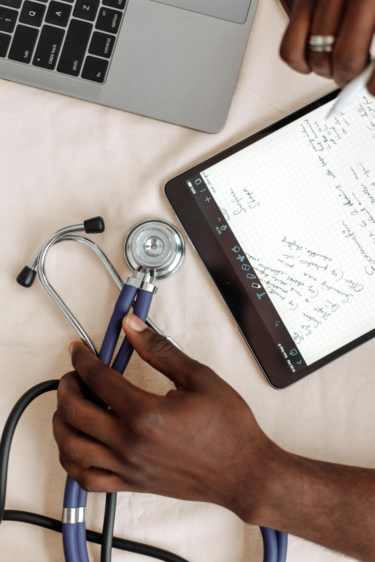 stethoscope, laptop and tablet located on the table